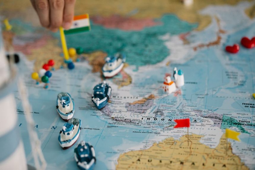 Mapa-múndi com pequenos navios e bandeiras indicando diferentes localidades e rotas comerciais globais.