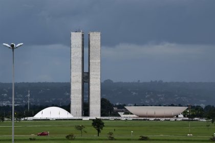 Vista externa do Congresso Nacional do Brasil, em Brasília, com suas cúpulas e torres diante do céu claro.