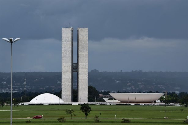 Vista externa do Congresso Nacional do Brasil, em Brasília, com suas cúpulas e torres diante do céu claro.