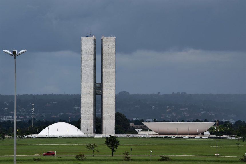 Vista externa do Congresso Nacional do Brasil, em Brasília, com suas cúpulas e torres diante do céu claro.